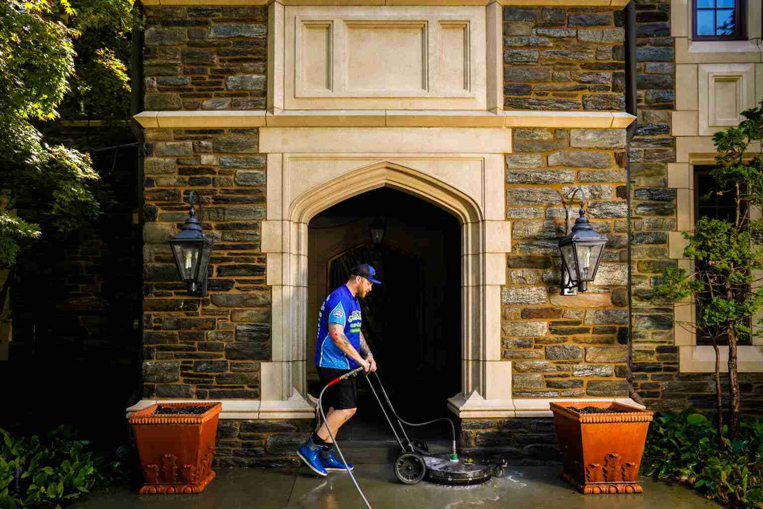 A professional pressure washing a cement floor.